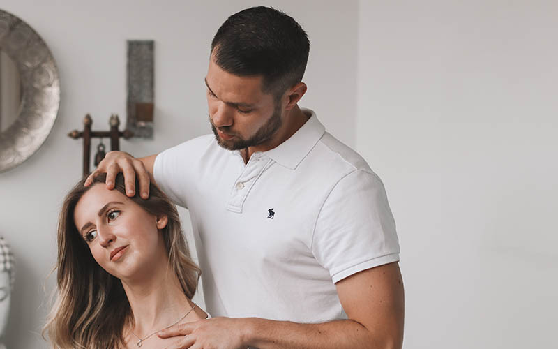 Physiotherapeut behandelt Nacken und Halswirbelsäule einer Patientin